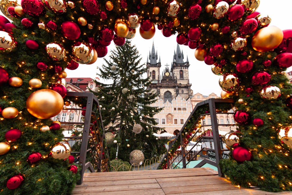 Christmas market in Prague with festive decorations and the Church of Our Lady before Týn